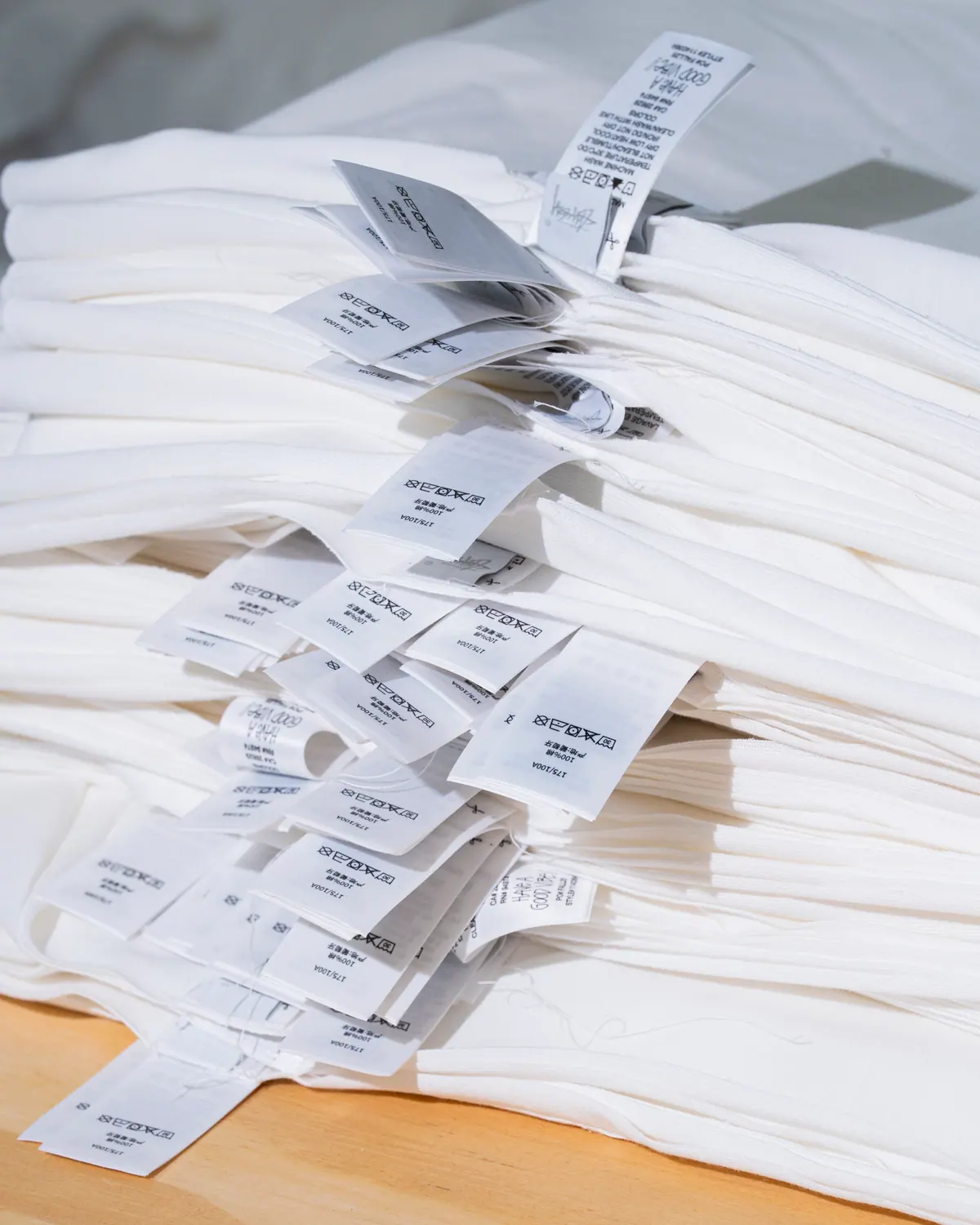 A stack of woven care and size labels waiting to be sewn in