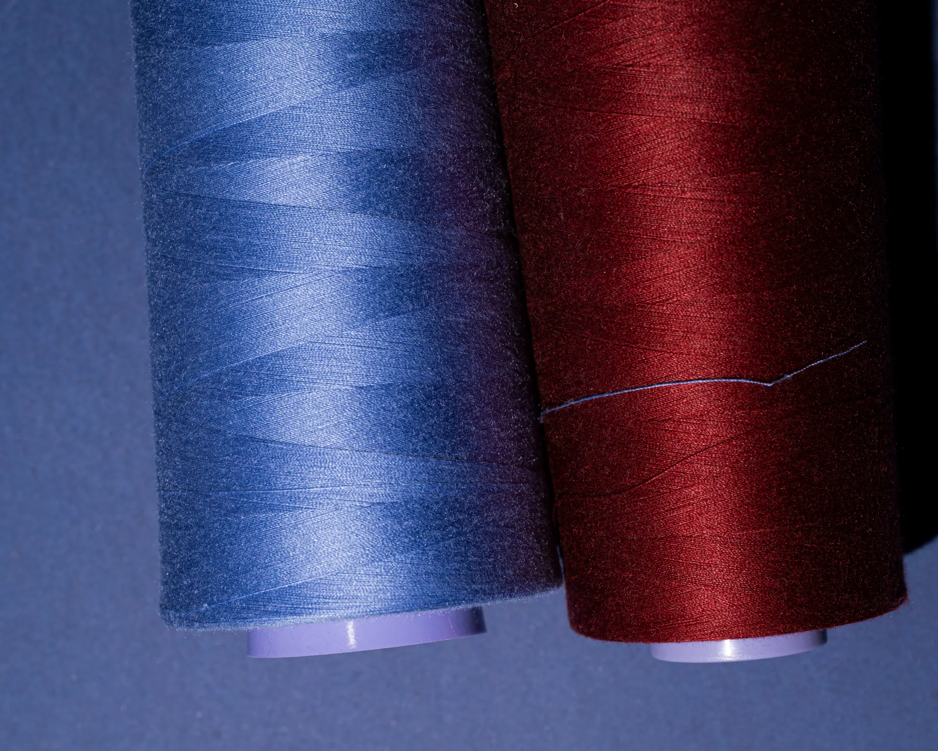 Navy and red sewing thread cones side by side