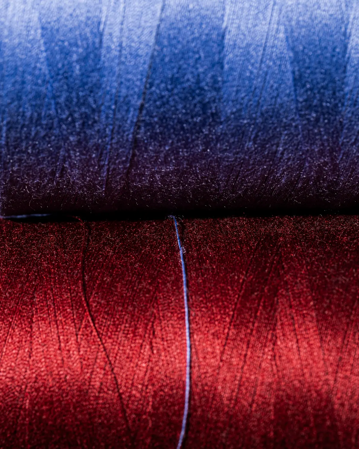 Blue and red yarn cones stacked at a spinning partner