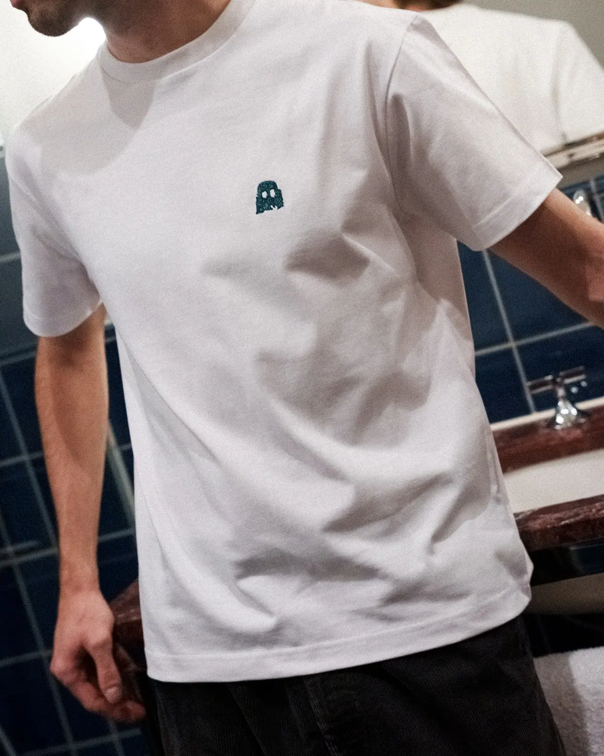 Château Royal white T-shirt with a small embroidered ghost, worn in the hotel