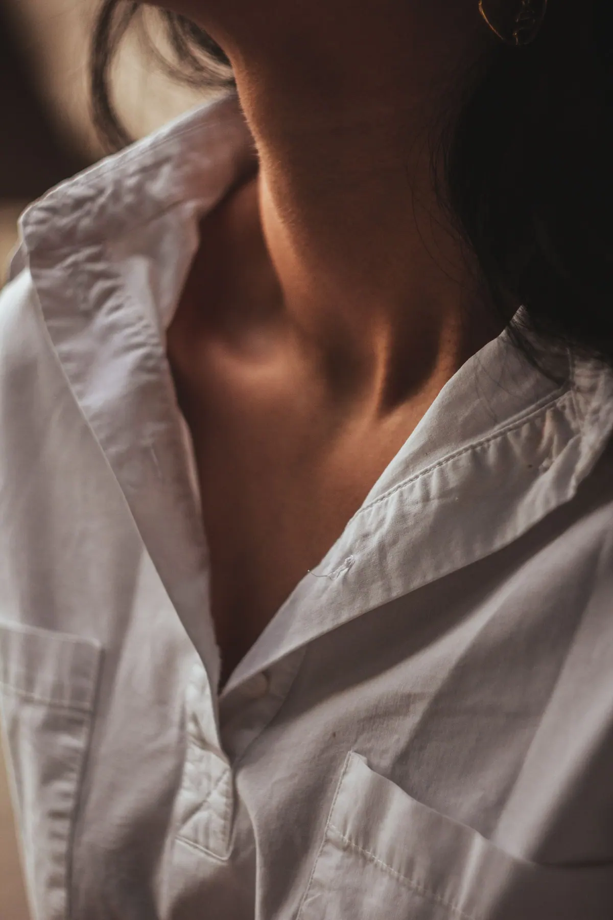 Open white cotton shirt collar in soft window light