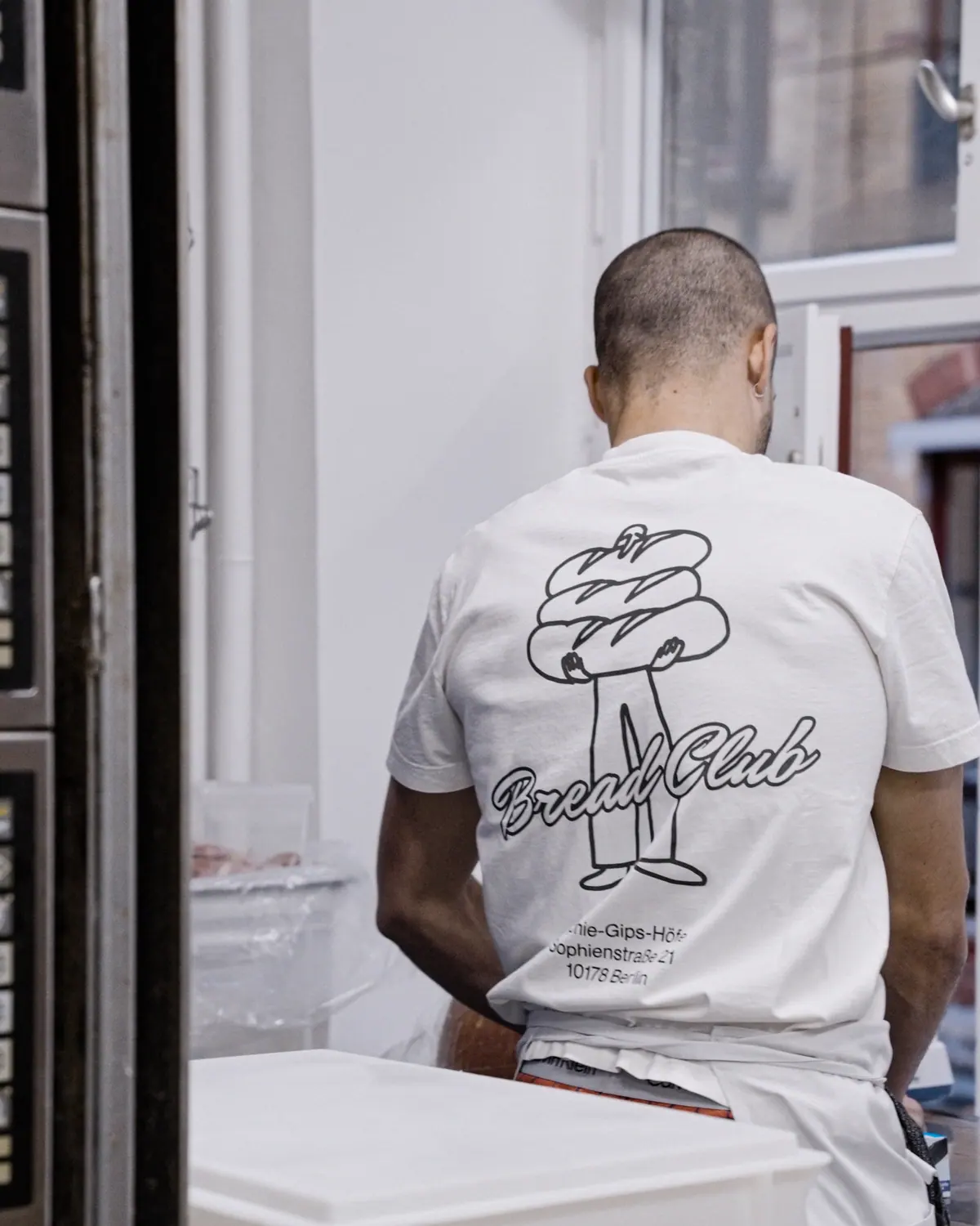 Sofi Bakery team member from behind in a white T-shirt with the Bread Club print